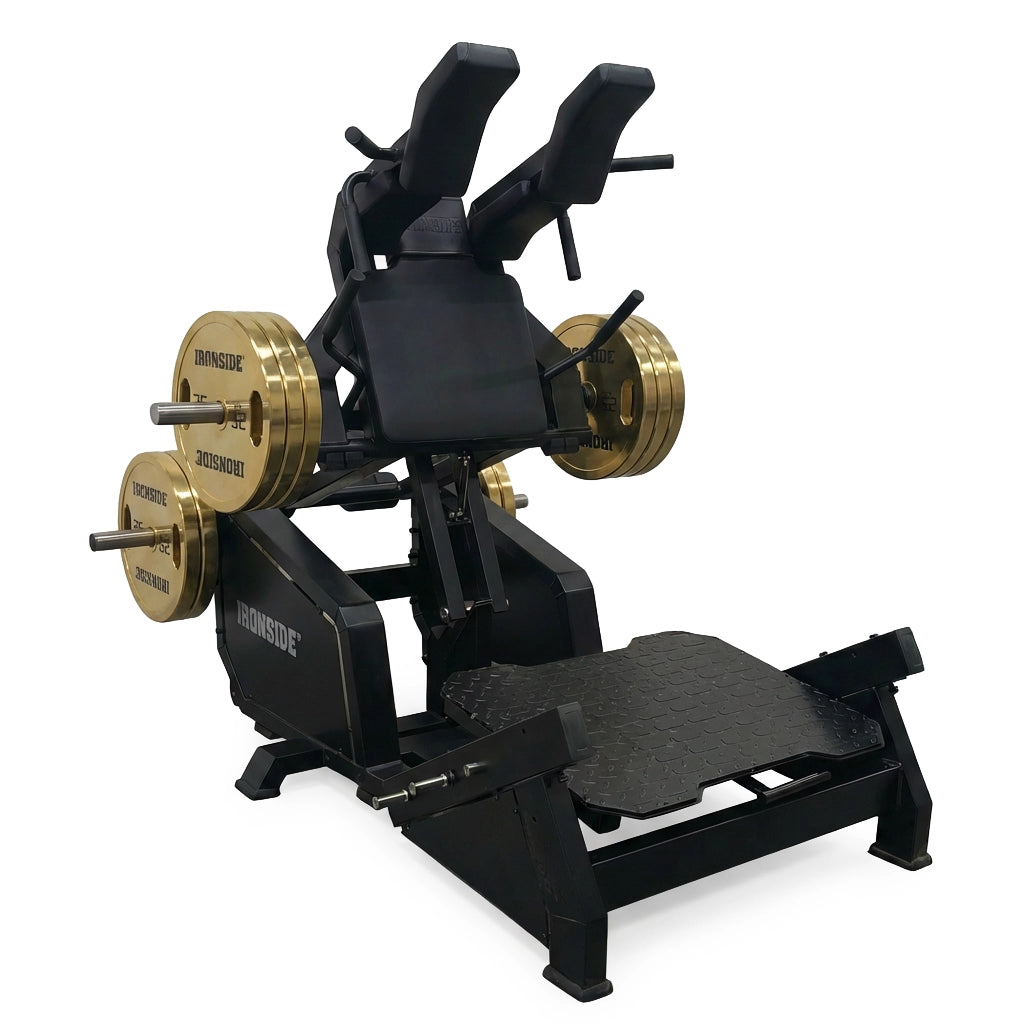 V-squat plate loaded comercial con trayectoria guiada, enfoque en glúteos y cuádriceps, bajo impacto articular y estructura estable para uso intensivo.